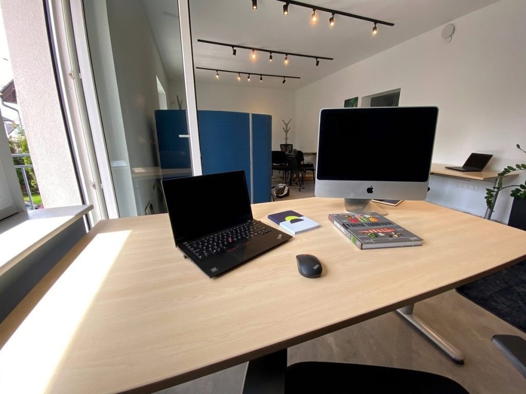 Világos coworking asztal laptoppal és monitorral az F49 közösségi irodában, Budaörs